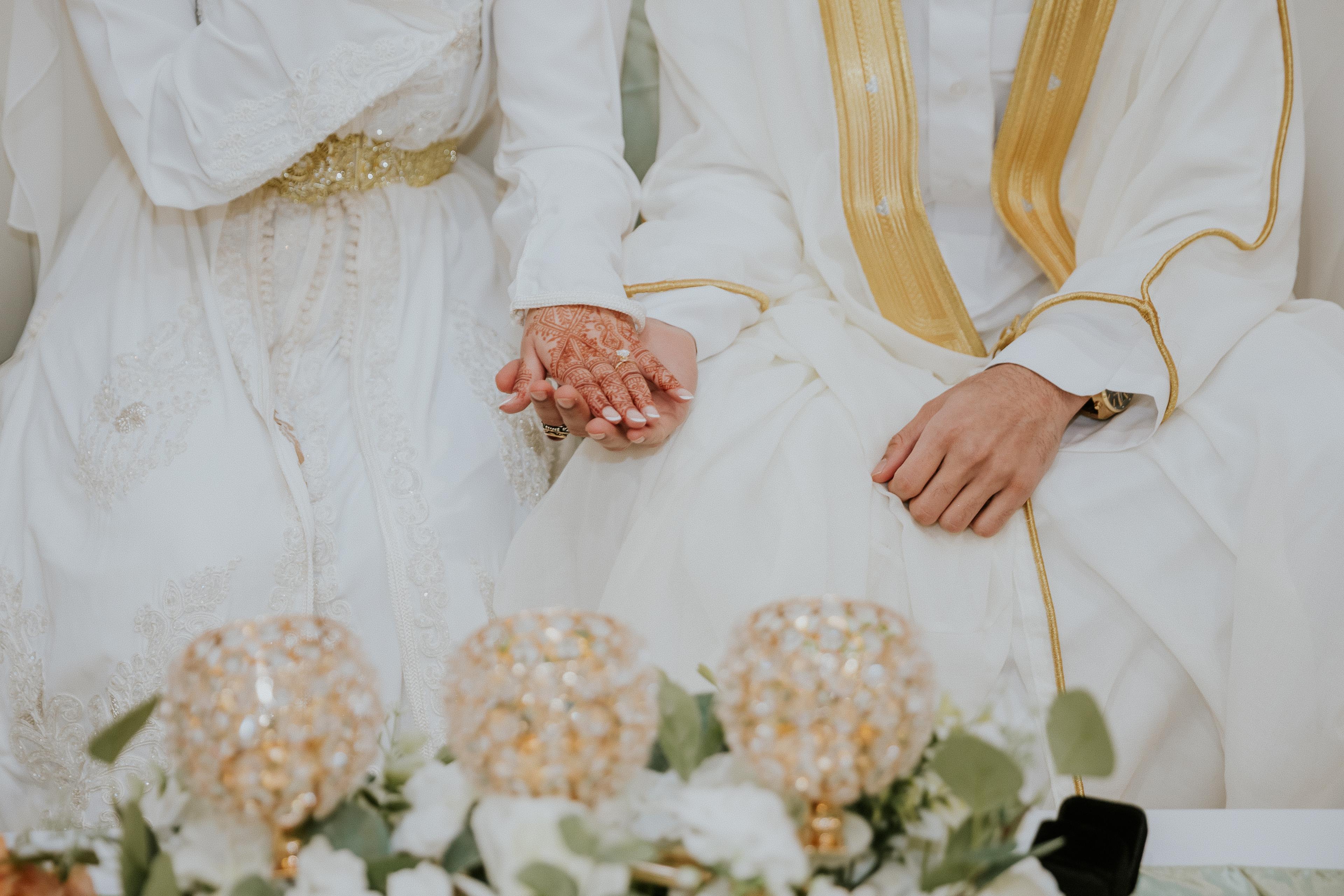 Bride and groom holding hands — wedding ring detail
